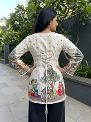 Woman wearing a traditional outfit with intricate patterns outdoors.