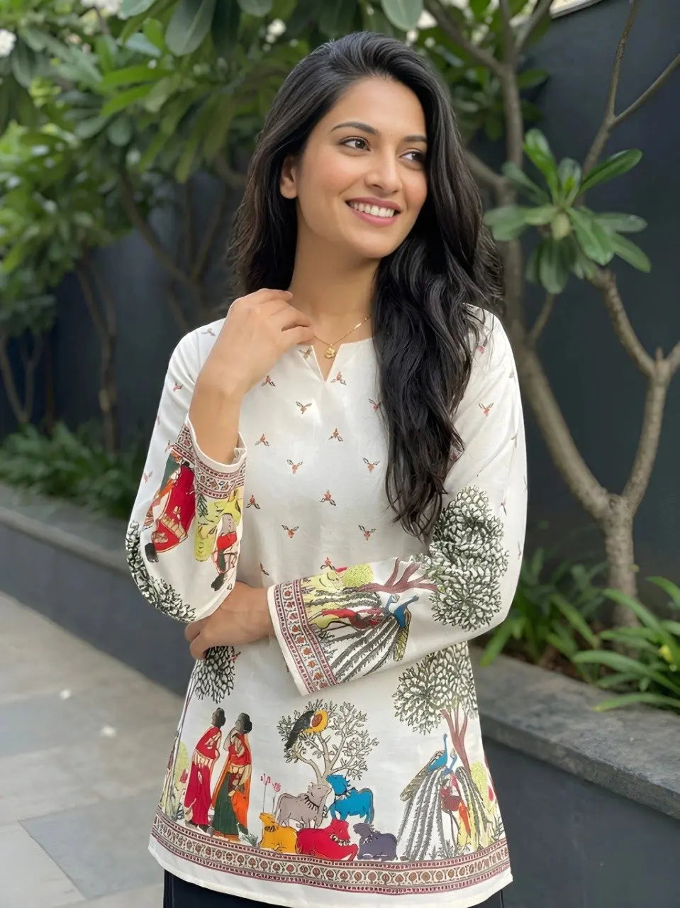 Woman wearing a white blouse with colorful patterns outdoors