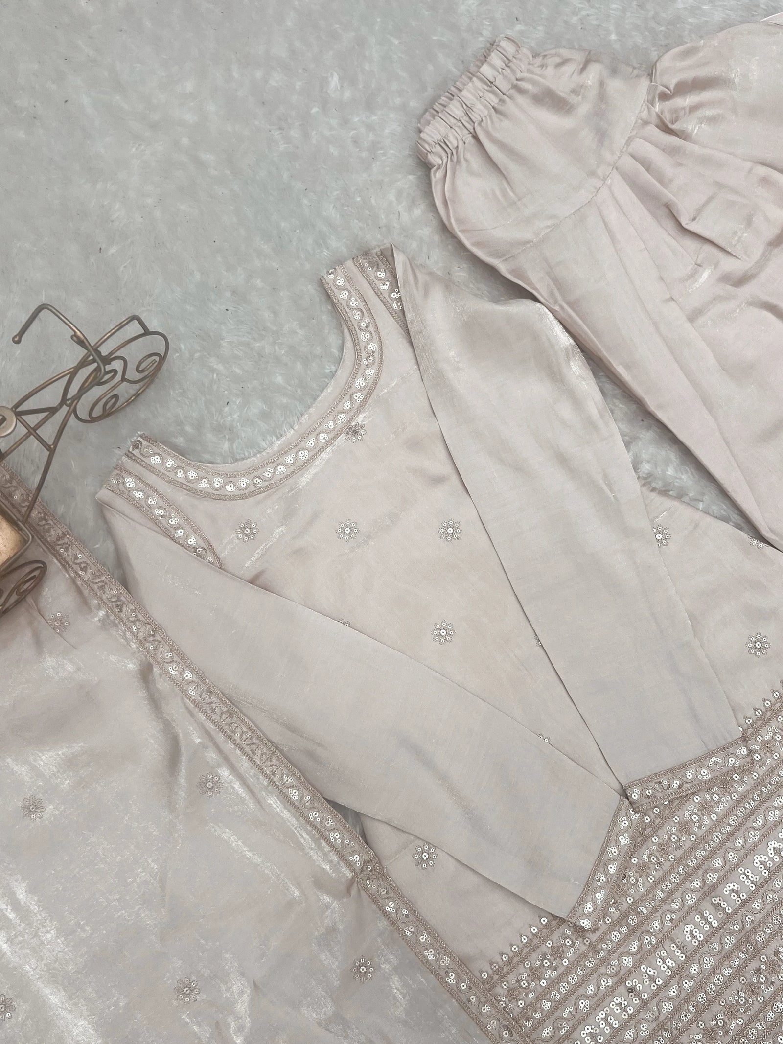 Light gray embroidered garment on a textured surface