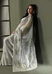 Elegant woman in embroidered saree against a dark studio background