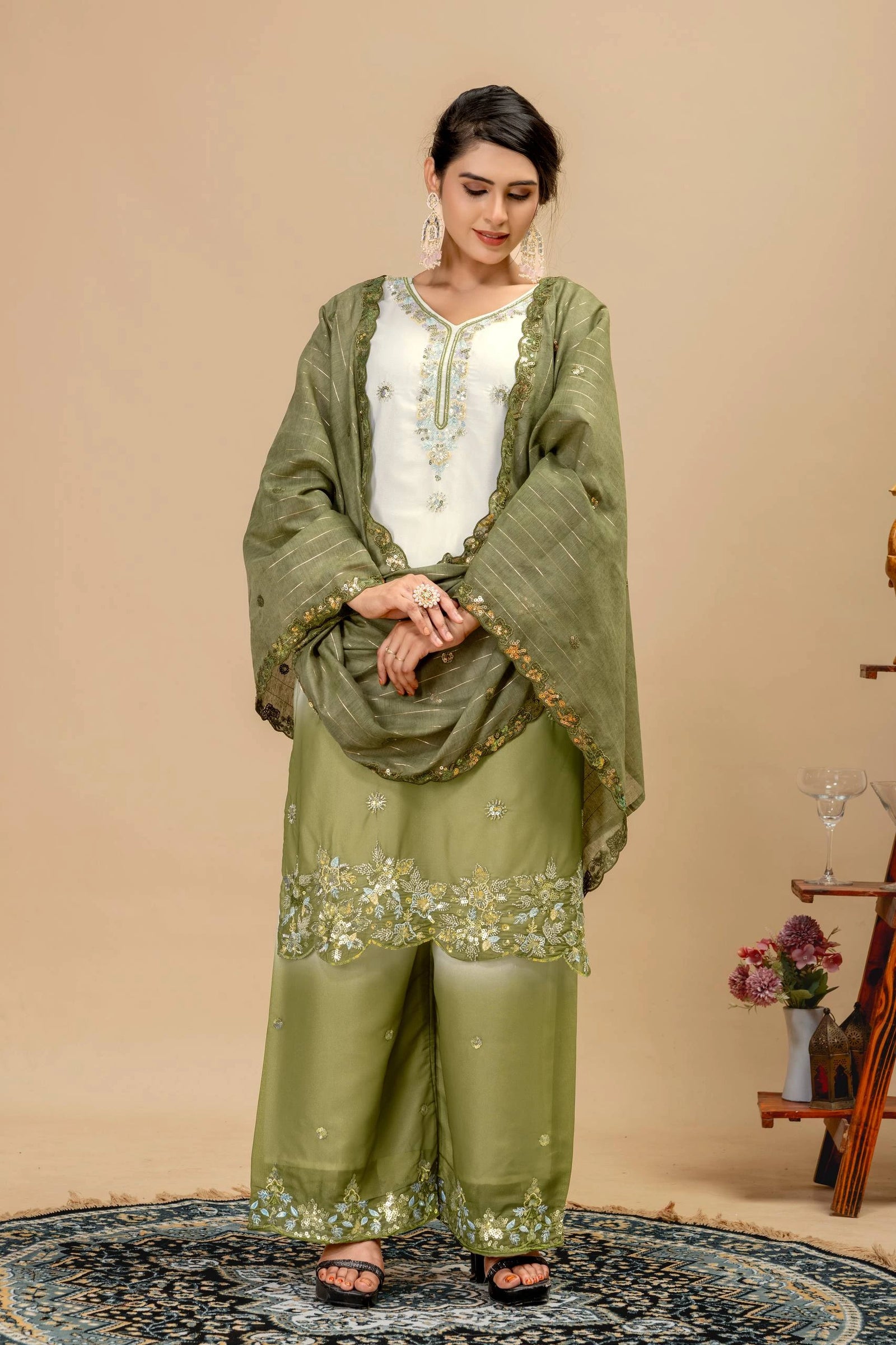 Woman wearing a green traditional outfit with a beige background