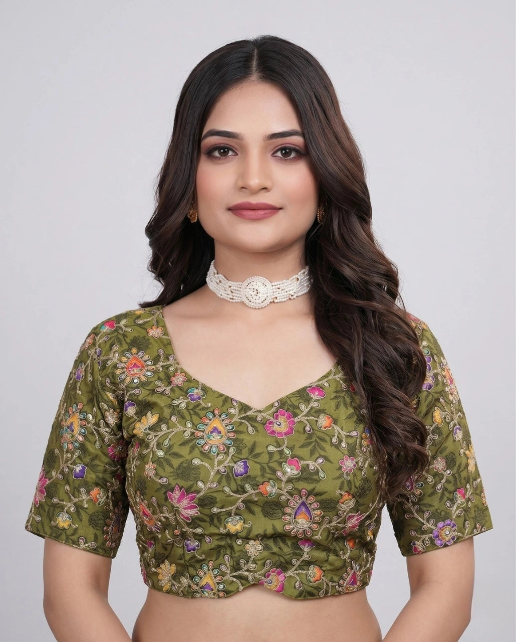 Woman wearing a green floral blouse against a plain background
