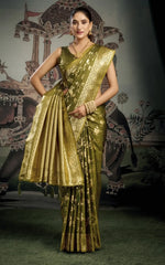 Woman wearing a gold saree with a traditional backdrop