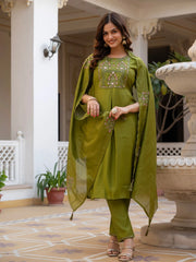 Woman in a green traditional outfit standing on a decorative patio.