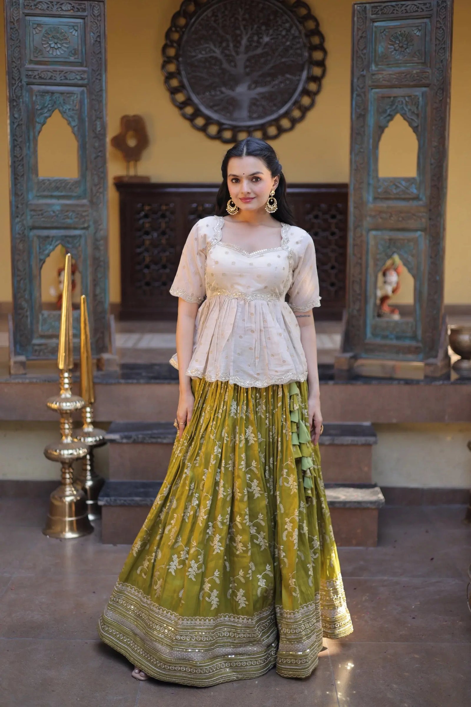 Woman in a traditional outfit standing in a decorated room with decorative elements.