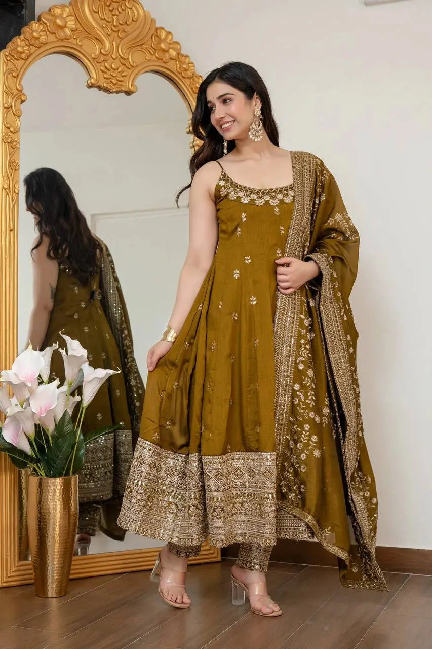 Woman in a mustard yellow traditional outfit standing in front of a mirror.