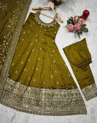 Green embroidered traditional outfit with a dupatta on a light gray surface.