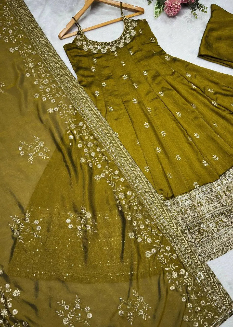 Green embroidered dress with matching dupatta on a marble surface