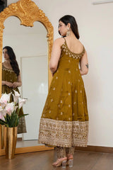 Woman in a mustard yellow traditional outfit standing in front of a mirror.