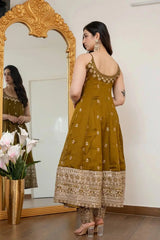 Woman in a mustard yellow traditional outfit standing in front of a mirror.