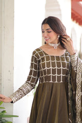 Woman wearing a traditional outfit with intricate patterns indoors.