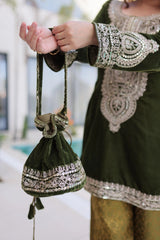 Person holding a green embroidered handbag with traditional attire