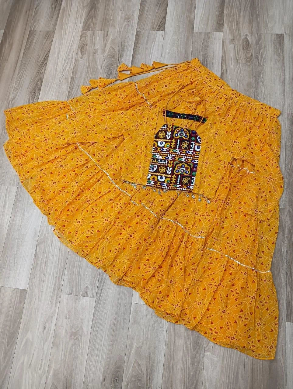 Yellow floral dress with a colorful pocket on a wooden floor