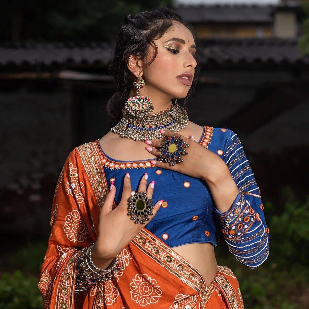 Woman in traditional attire with jewelry against a blurred background