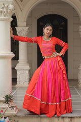 Woman in a red and pink traditional outfit standing outdoors.
