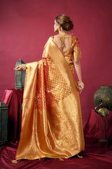 Woman in a gold saree standing against a red background