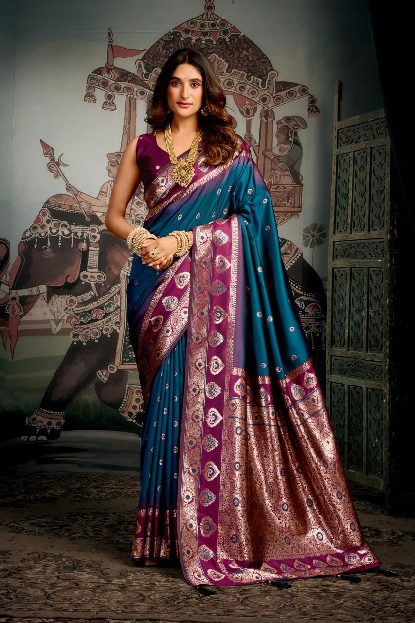 Woman in a traditional saree with intricate patterns against an ornate wall.