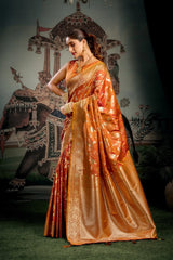 Woman in an orange saree standing in front of a decorative backdrop