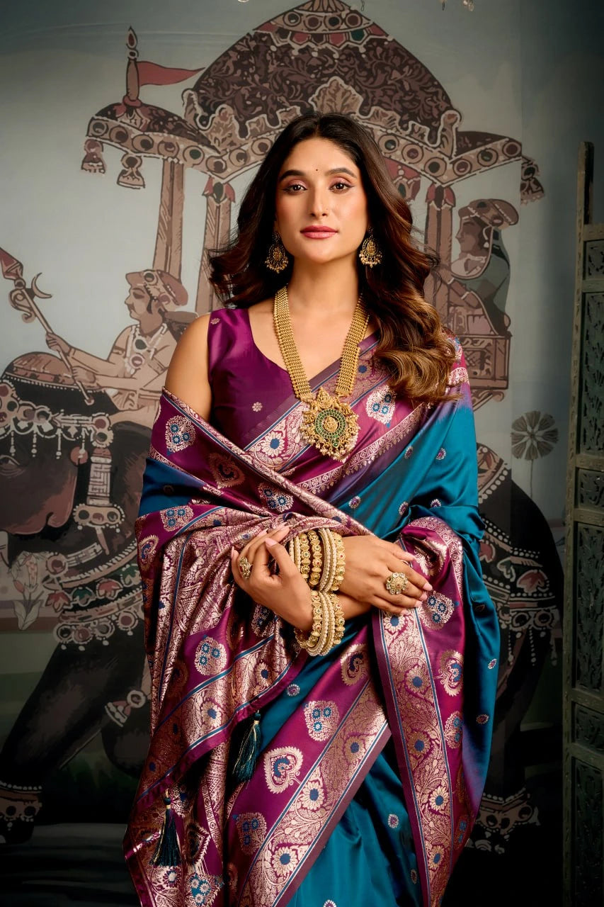 Woman in a traditional saree with jewelry against an ornate wall.