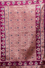 Decorative fabric with intricate paisley pattern on a purple background