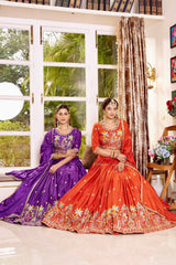 Two women in traditional outfits sitting in a well-decorated room with large windows.