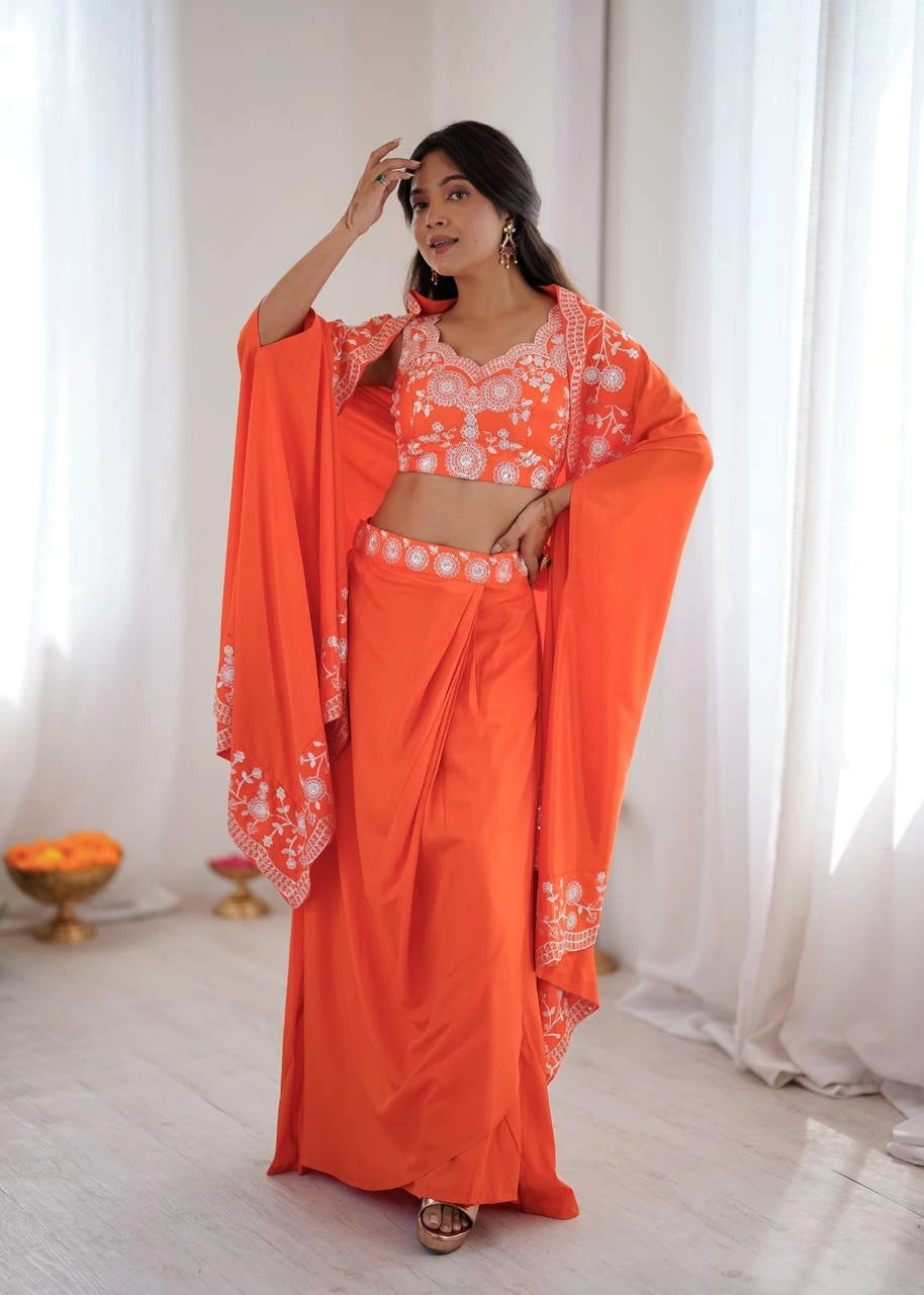 Woman wearing an orange saree with white patterns in a bright room.