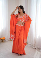Woman wearing an orange saree with white patterns in a bright room.