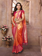Woman wearing a traditional orange and pink saree with a brick wall background
