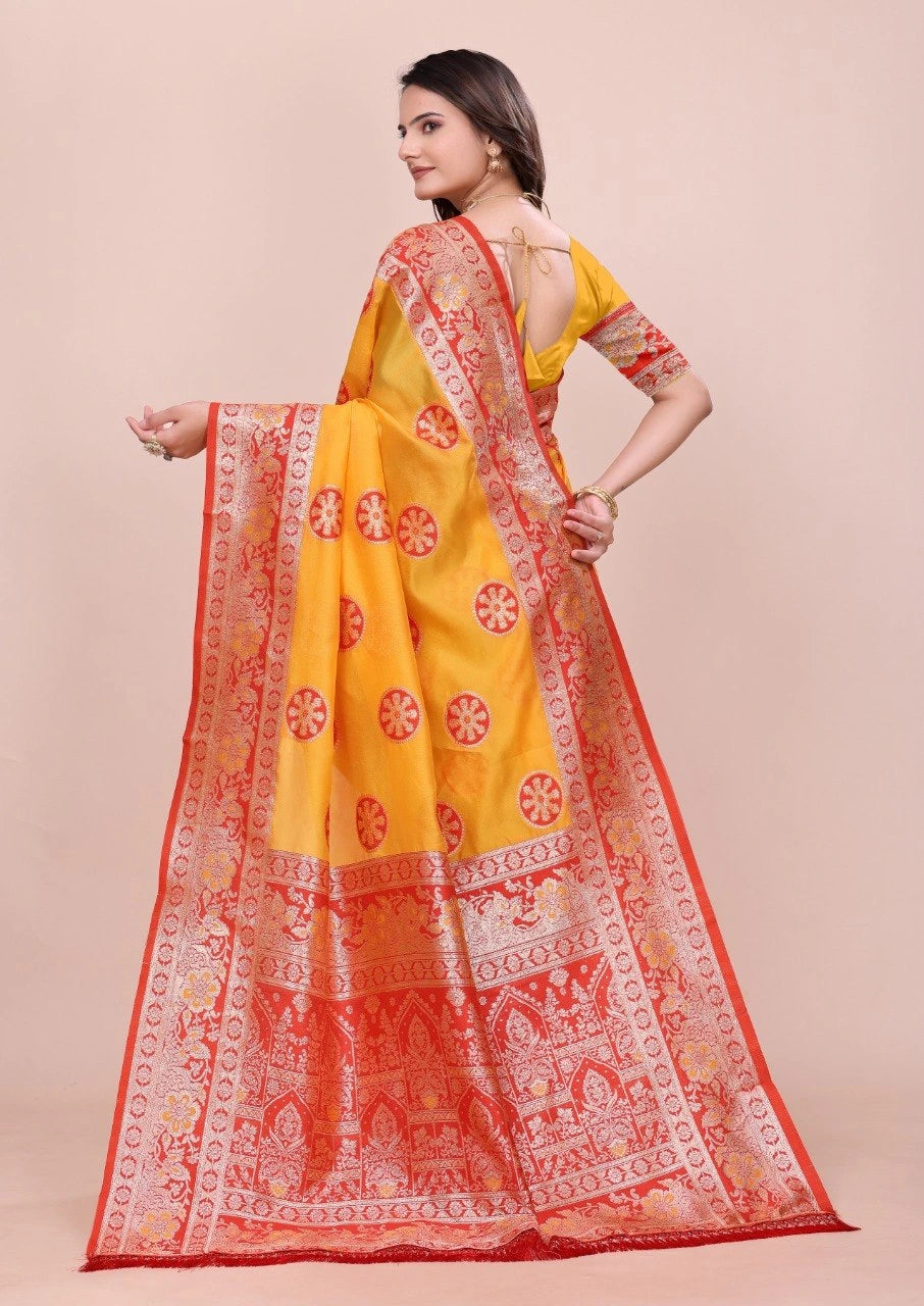 Woman wearing a yellow and orange saree with a beige background