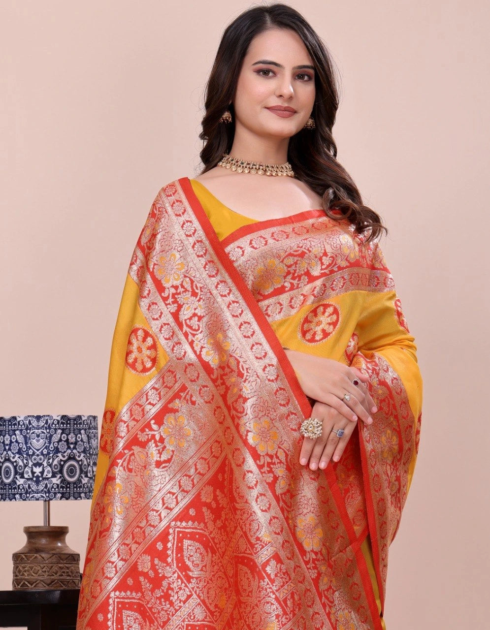Woman wearing a red and yellow saree with a beige background