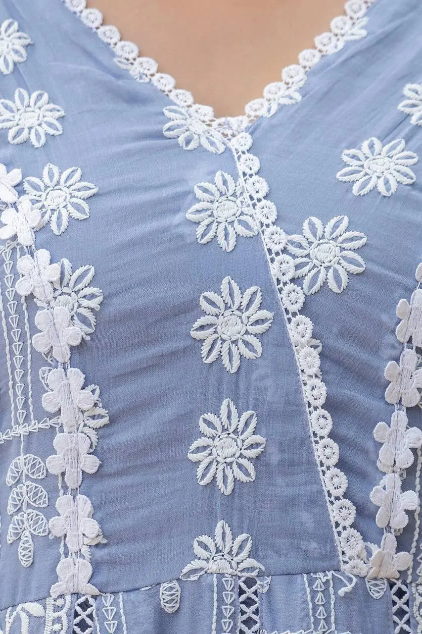 Close-up of a blue fabric with white floral embroidery