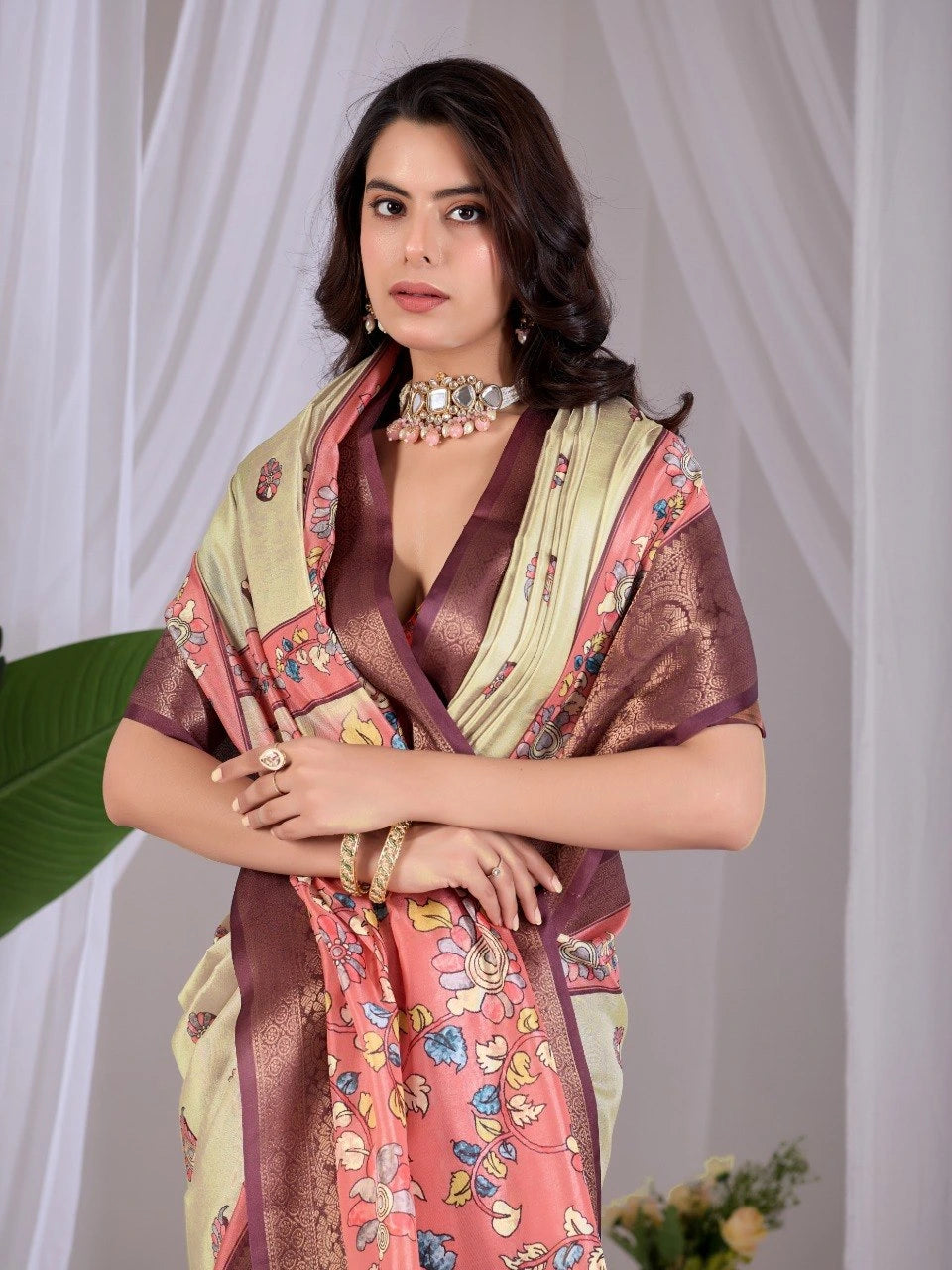 Woman wearing a colorful traditional outfit with a patterned scarf against a white curtain background
