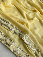 Close-up of yellow fabric with decorative silver sequin border