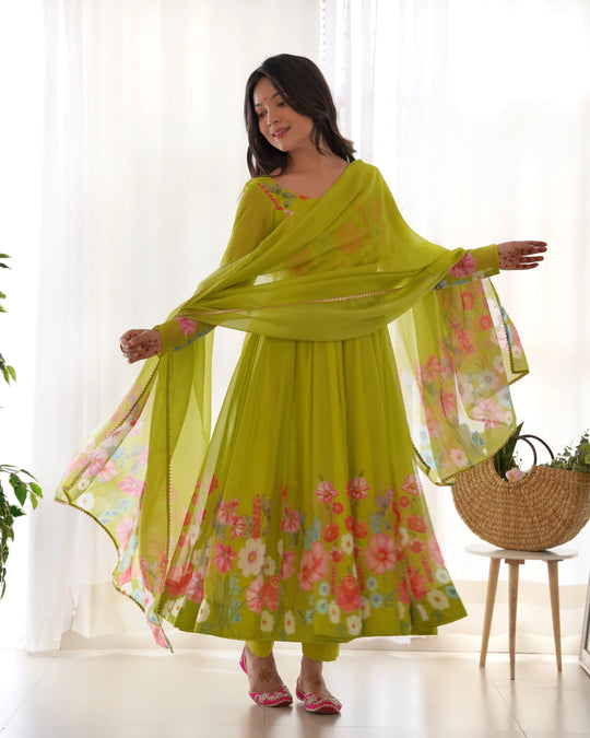 Woman wearing a green floral dress with a matching dupatta in a bright room.