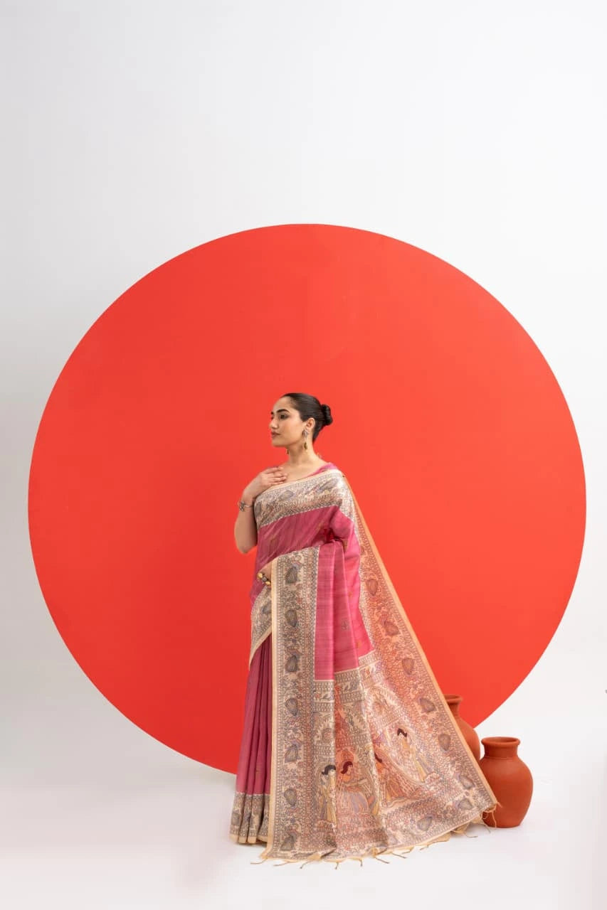 Woman in a pink and gold saree standing against a white background with a large red circle.