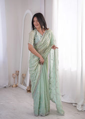 Woman wearing a light green saree with a white background