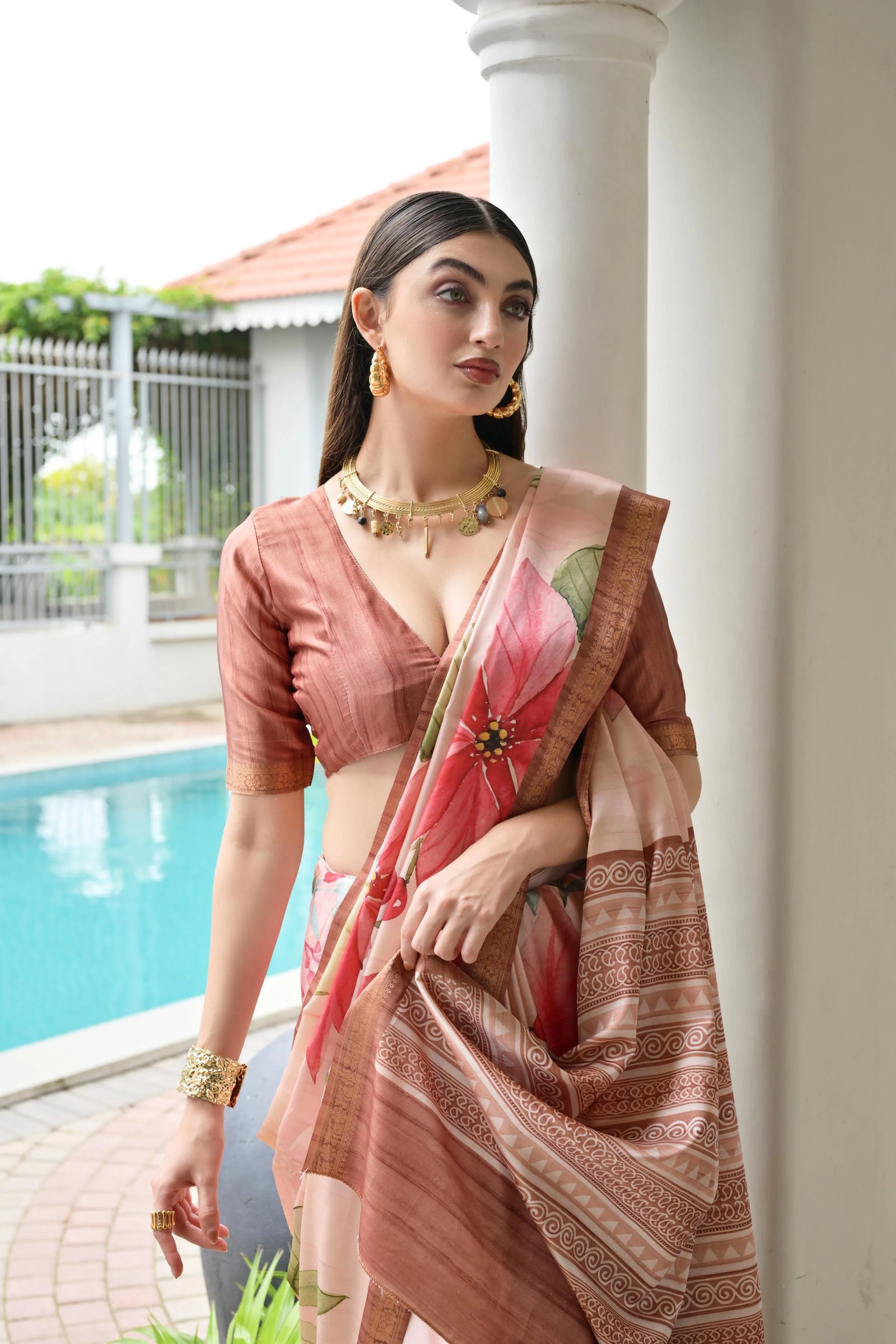Woman in a traditional saree by a poolside