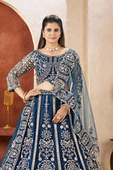 Woman wearing a blue embroidered traditional outfit with a beige background