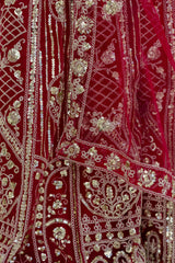 Close-up of a red fabric with intricate gold embroidery and sequin work.