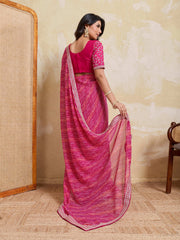 Woman wearing a pink saree with a matching blouse in a room setting.