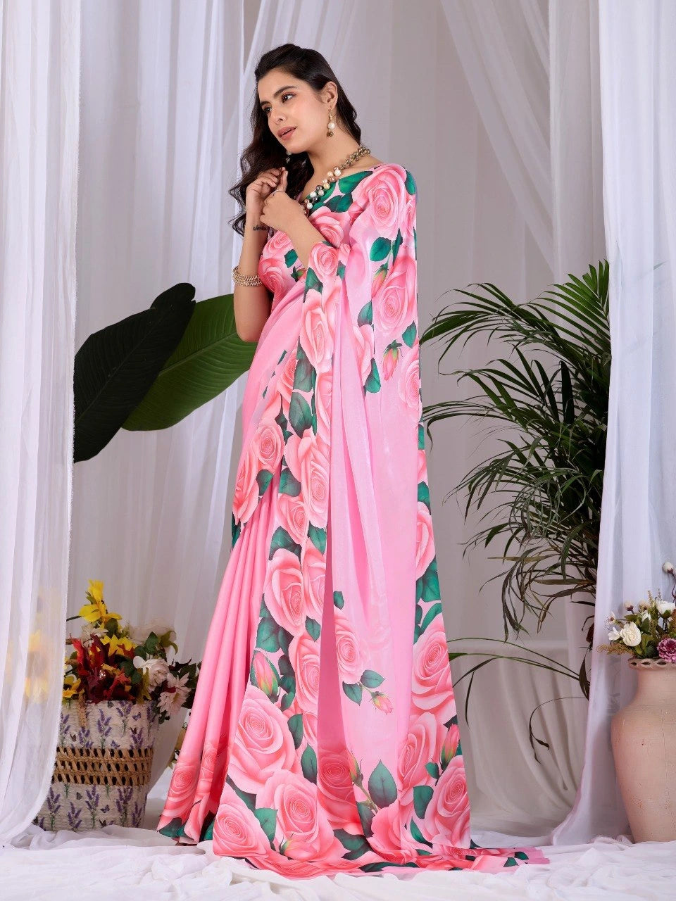 Woman wearing a pink floral saree with a white background