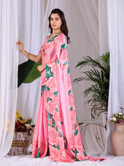 Woman wearing a pink saree with floral patterns against a white curtain background