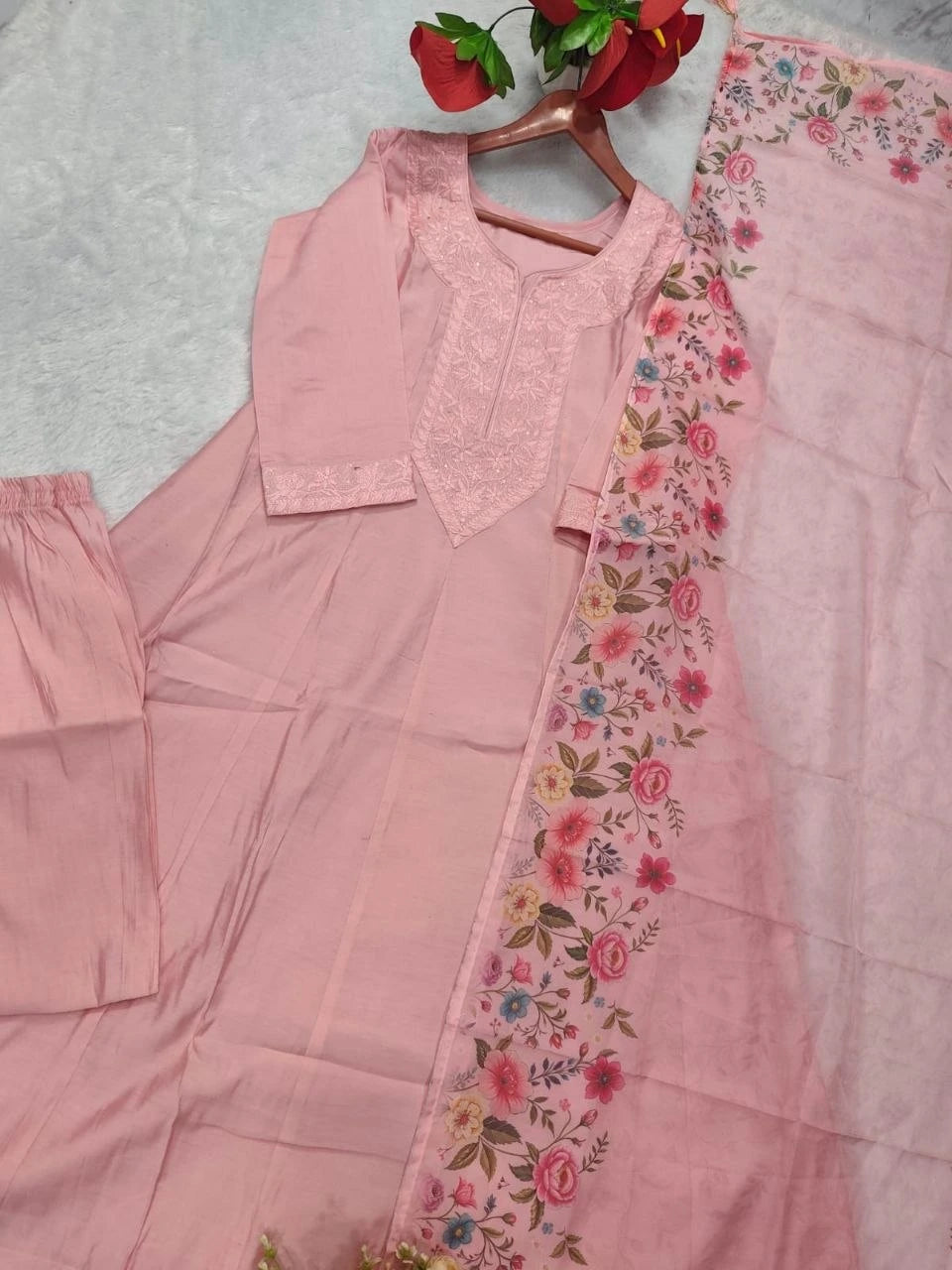 Pink traditional outfit with floral border on a light gray background
