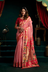 Woman wearing a pink saree with floral patterns in a decorative setting.