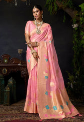 Woman in a pink saree with floral patterns against a dark background