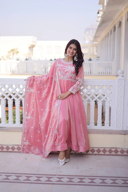 Woman in a pink traditional outfit standing on a balcony