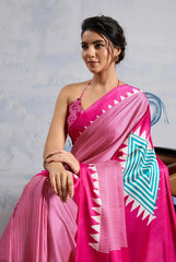 Woman wearing a pink saree with a geometric design on a light gray background