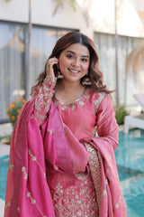 Woman in a pink traditional outfit standing by a pool
