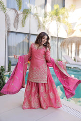 Woman in a pink traditional outfit standing by a poolside.