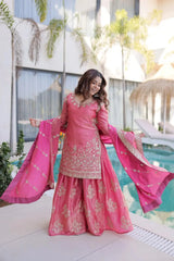 Woman in a pink traditional outfit standing by a poolside.